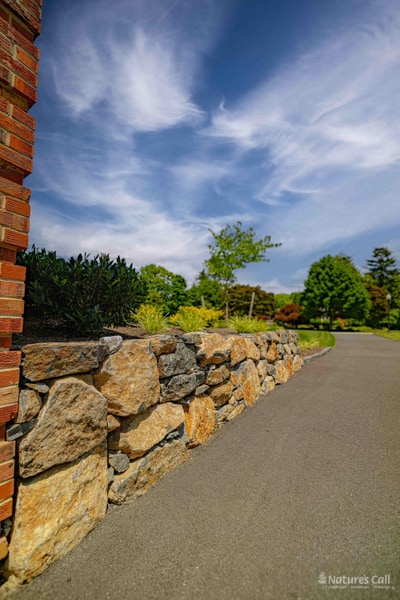 Stone wall leading from brick corner with dramatic sky, Greenville Delaware